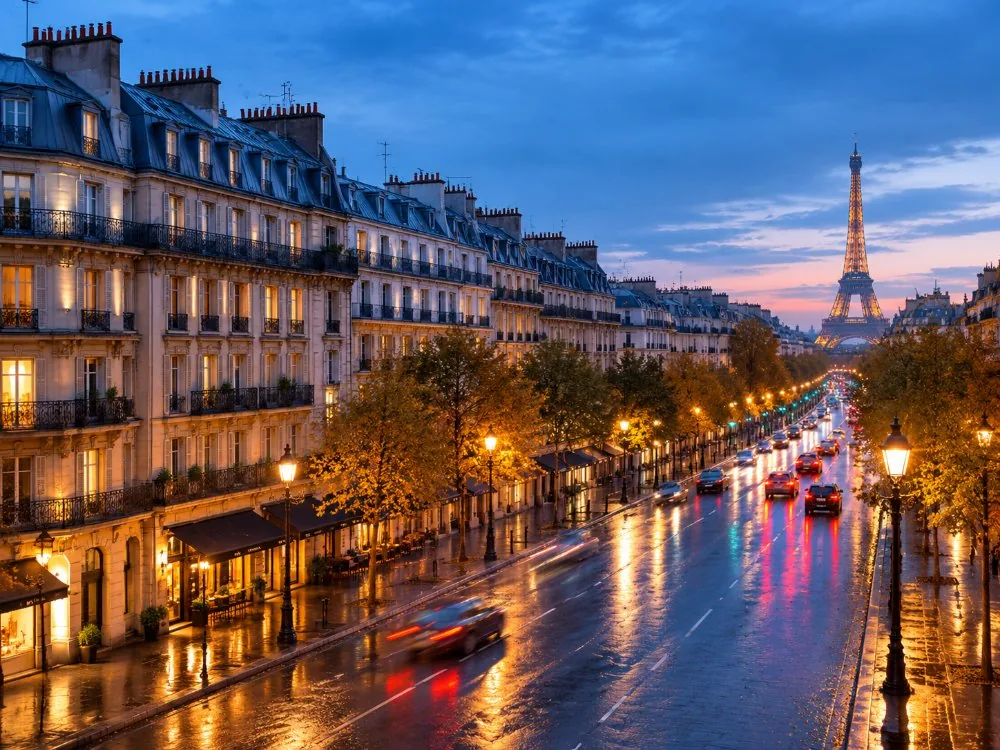 Boulevard Haussmann le soir, lampadaires allumés et immeubles haussmanniens